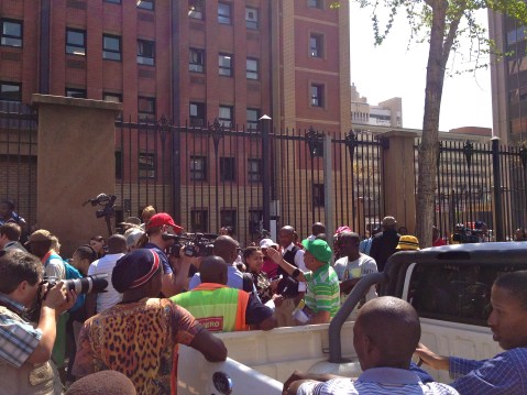 17_The media pack was intiruged by the man in the green shirt.